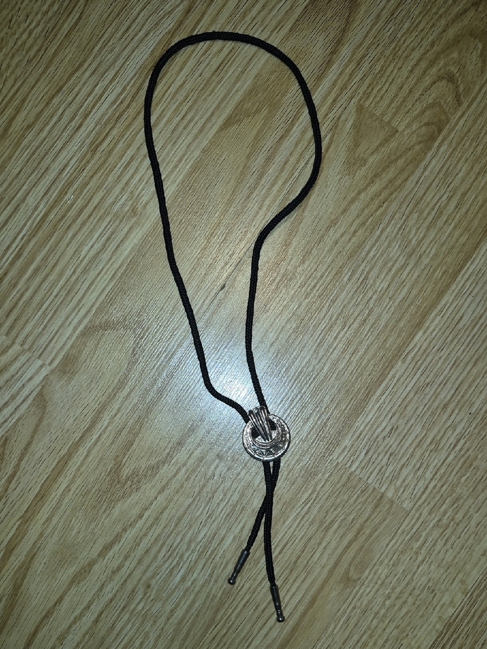Vintage Western-style bolo tie featuring a silver-toned decorative slide